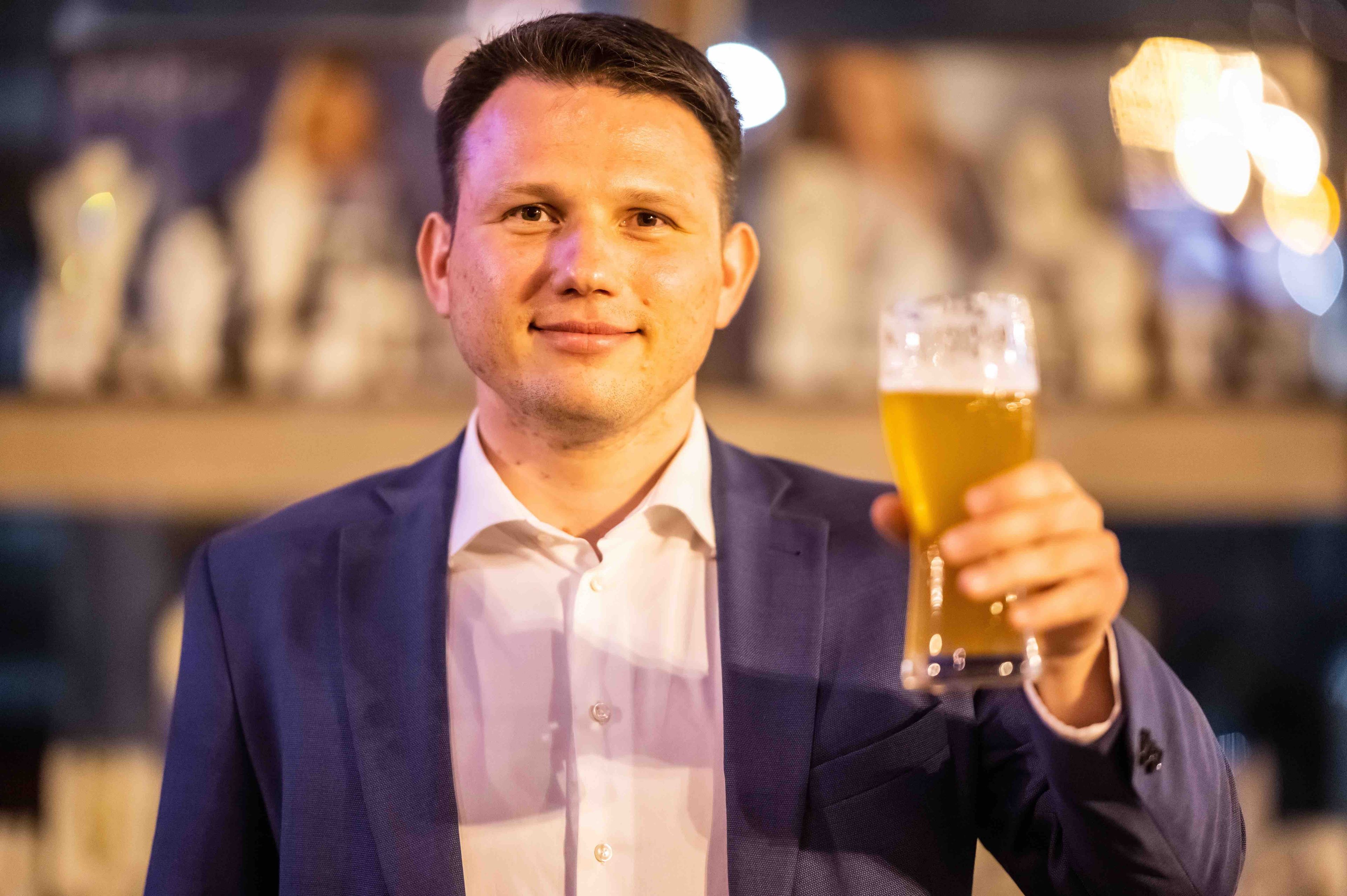 Sławomir Metzen podnosi szklankę z piwem do toastu.